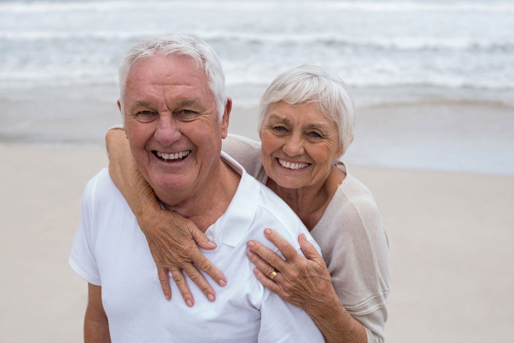 Senior couple smiling on the beach